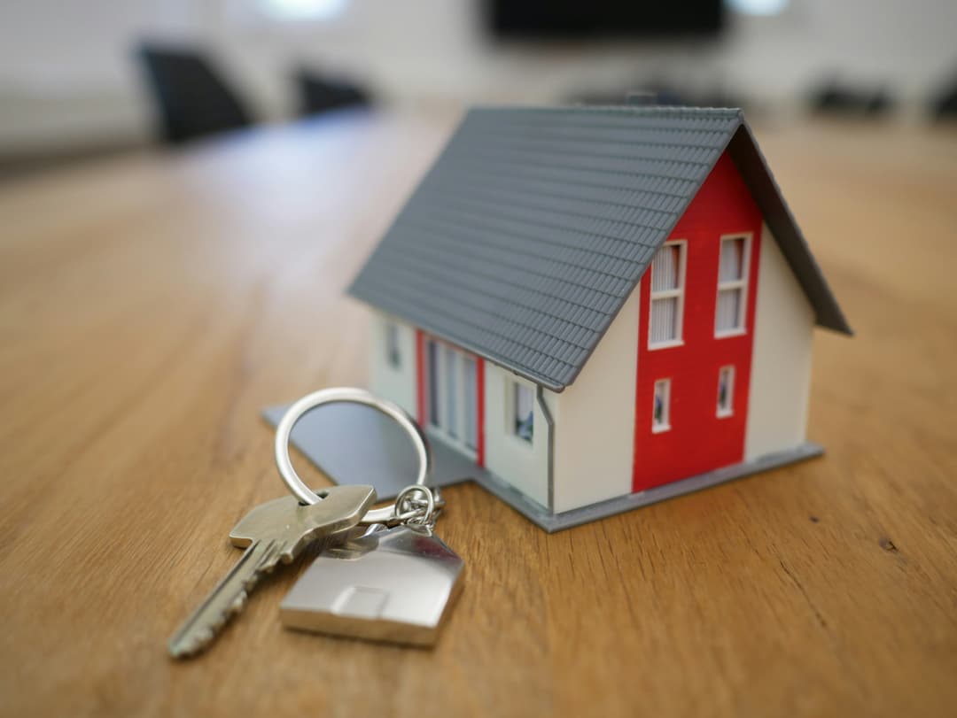 Young couple holding house keys in front of their new home